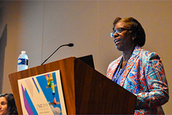 A Black woman presenting at a conference.