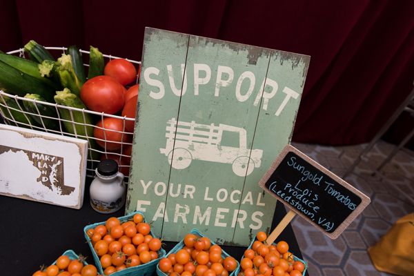 一块牌子上写着“支持当地农民”它和各种蔬菜一起放在会议桌上。